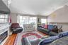 Living room featuring lofted ceiling, wood finished floors, a stone fireplace, and recessed lighting