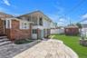 Rear view of house with a shed, a fenced backyard, a balcony, brick siding, and a patio