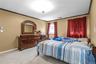 Bedroom with ornamental molding and light colored carpet