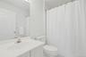 Main Bathroom on top level has bath and light fixtures, light tiles and line closet