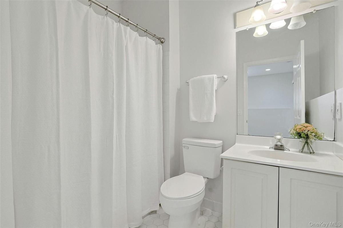 Main level full bath, with tub and lights tiles