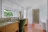 Spa-inspired bathroom with double vanity, oversized walk-in shower, and soaking tub with views over the gardens