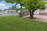 Expansive paver patio featuring a circular design, bordered by a mature tree