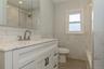 Bathroom featuring a white vanity with an integrated sink, brushed nickel faucet, and a wall-mounted mirrored medicine cabinet