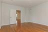 Upstairs bedroom featuring wood-finish flooring, light neutral wall tones, recessed lighting, and a paneled interior door with lever hardware