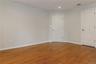 Interior room featuring wood-finish flooring, light-toned walls, and two white paneled closet  doors