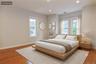 Upstairs Bedroom featuring wood-finish flooring, recessed lighting, and multiple windows with white trim (virtually staged)