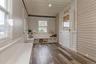 Entryway featuring wood-finish flooring, white paneled walls, and a built-in bench