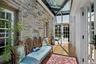 This thoughtfully designed glass-enclosed passage preserves the original stone wall while dramatic skylights flood the space with natural light, creat