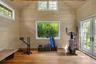 Light-filled wellness studio with vaulted ceilings and French doors opening to the gardens, ideal for yoga, meditation, fitness, or creative pursuits