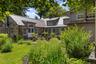 An inviting outdoor space with views across the surrounding gardens, thoughtfully positioned between the home’s east and west wings