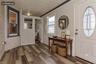 Entryway featuring a white paneled door with an oval stained-glass insert, wood-finish flooring, and white beadboard wainscoting(virtually staged)