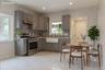 Modern kitchen featuring grey cabinetry, stainless steel appliances, a mosaic tile backsplash, a farmhouse sink, and white tile flooring (virtually st