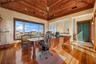 A private executive office with rich wood detailing, soaring ceilings, and views that make working from home feel a little unfair.