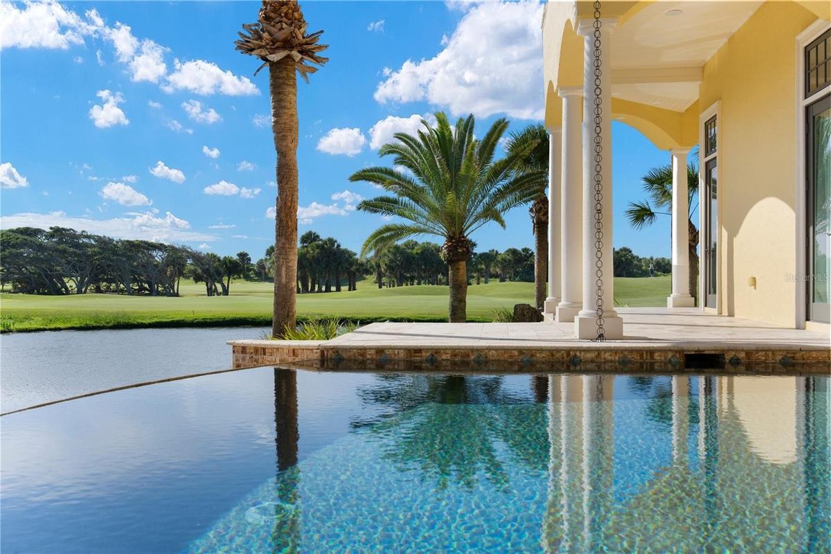 An infinity-edge pool stretches toward the water, creating a serene setting where morning swims, afternoon sunshine, and breathtaking sunsets become p