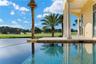 An infinity-edge pool stretches toward the water, creating a serene setting where morning swims, afternoon sunshine, and breathtaking sunsets become p