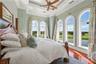 From the comfort of bed, watch the first light dance across the water and the greens beyond—a view that makes every morning feel like a getaway.