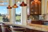 Morning espresso, evening wine, and front-row views of the fairway—all from a gathering space where conversation naturally settles around the island b
