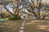 A winding stepping-stone path beneath moss-draped oaks leads to the yurt.