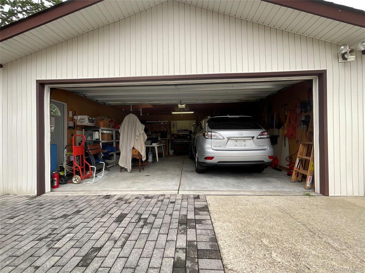 Two-car garage featuring light-colored vertical siding and a dark brown trim