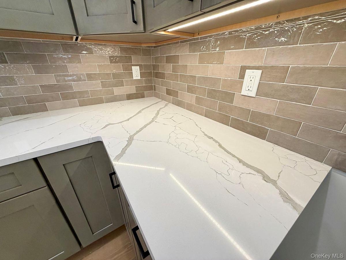 Gorgeous quartz countertops; lovely tiled backsplash. Tasteful colors.
