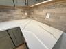 Gorgeous quartz countertops; lovely tiled backsplash. Tasteful colors.