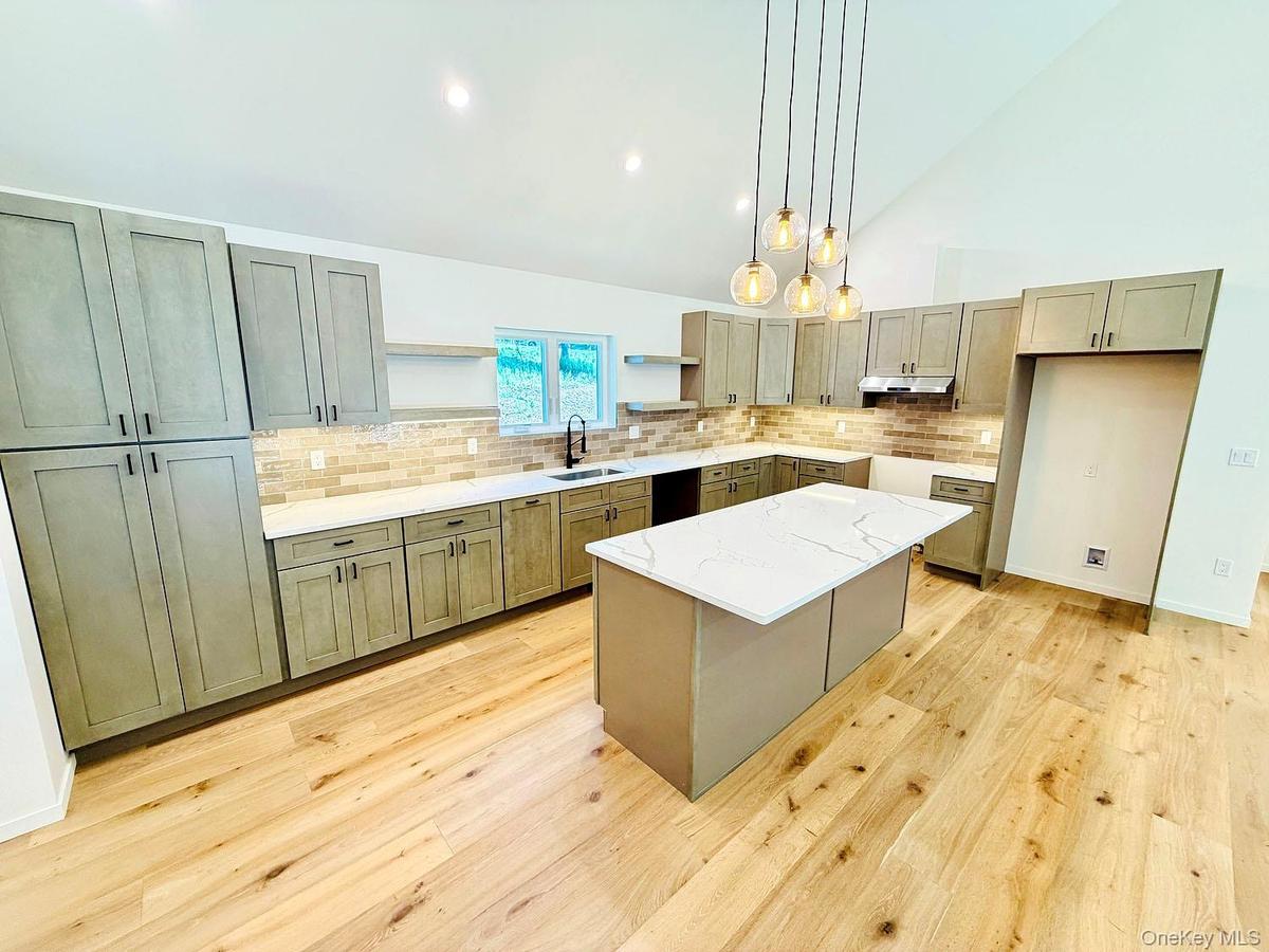 Gorgeous kitchen. Quartz island, lovely pendant lighting; so much counter space.