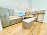 Gorgeous kitchen. Quartz island, lovely pendant lighting; so much counter space.