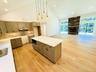 From kitchen looking into dining/living area. Gorgeous floors! LP gas fireplace, sliders to deck and back yard.
