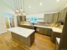 Beautiful pendant lighting, gleaming quartz countertops, spacious kitchen