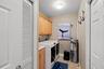 Laundry room off kitchen hallway m. Has built in sink and cabinetry for storage , a storage closet and water heater ac , electricity box room.