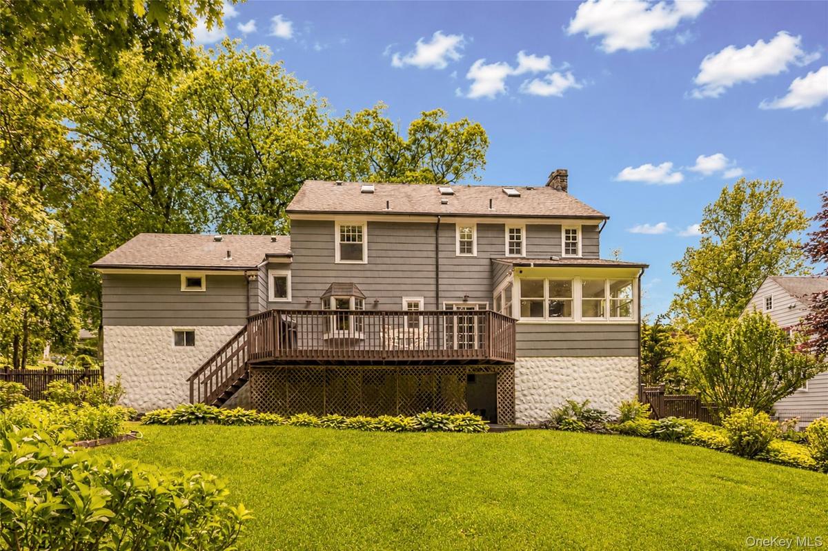 The ample deck overlooks the large private back yard with views of the Huntswoods.
