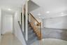 Split-level entryway featuring a carpeted staircase with a wood banister and white balusters