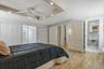 Recessed ceiling with integrated lighting, a ceiling fan, and wood-finish flooring