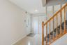 Entry foyer featuring neutral tile flooring, a white entry door with an oval-shaped decorative glass insert, and a built-in recessed light fixture