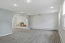 Spacious room featuring neutral carpeting, recessed lighting, and white baseboard trim