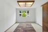 Bright room with a three-panel window, white walls, and light-toned tile flooring