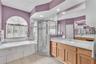 The walk-in shower has a rain head fixture and a built-in seat.