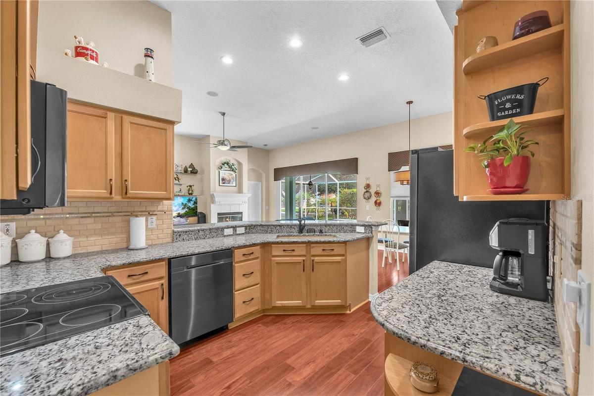 Chef-inspired kitchen Featuring black stainless steel appliances, abundant cabinetry, generous granite counter space, breakfast bar seating