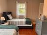 Bedroom featuring dark wood-style flooring and a decorative wall