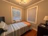 Bedroom with wood finished floors and ornamental molding