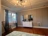 Bedroom featuring dark wood-type flooring, a chandelier, a decorative wall, heating unit, and crown molding