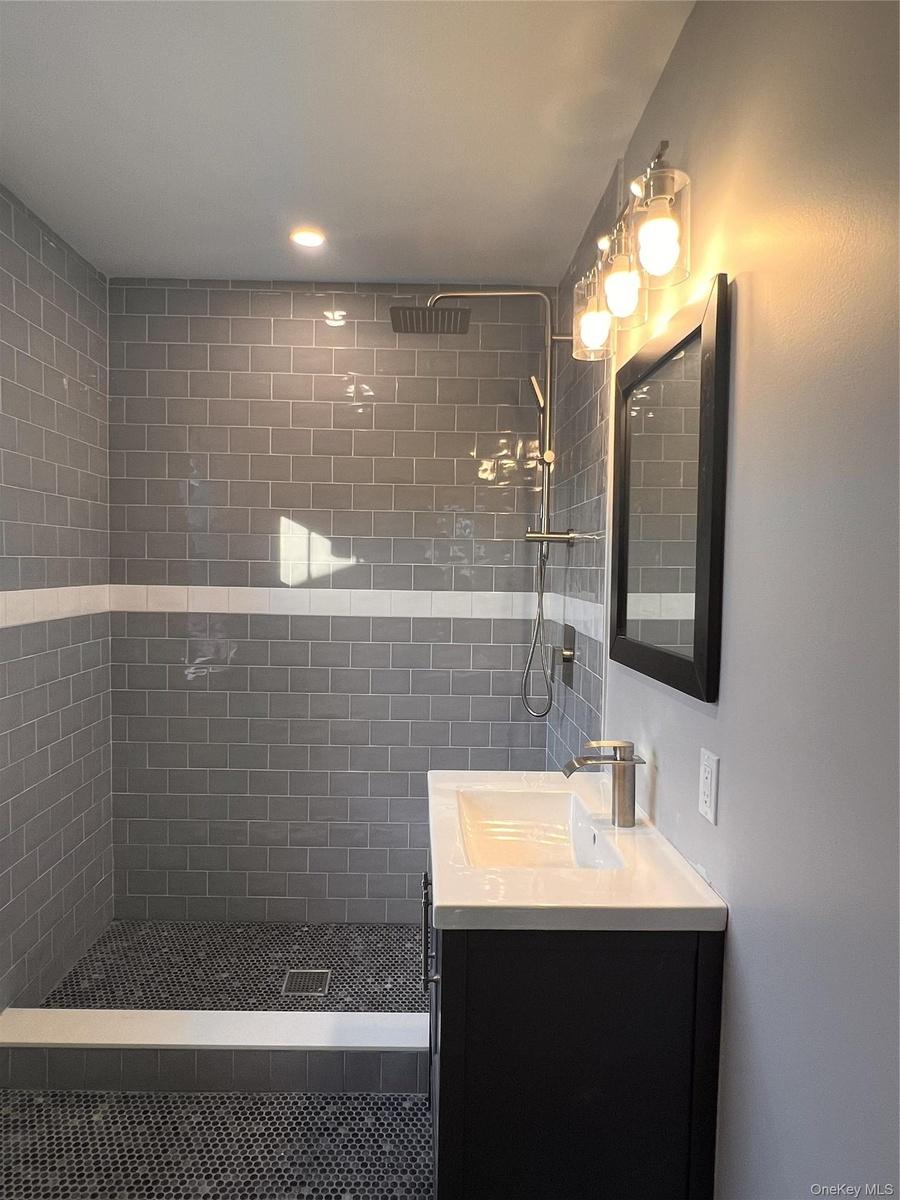 Full bathroom with tiled shower and vanity