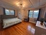 Bedroom featuring wood finished floors, multiple windows, and a chandelier