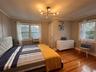 Bedroom featuring wood finished floors, a chandelier, and crown molding