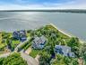 Waterfront property featuring extensive shoreline access, a private beach, and lush green landscaping