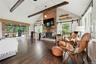 Living room with vaulted ceiling, wood burning fire place, free floating shelves, hardwood flooring