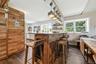 Rustic-inspired kitchen with a wood-clad breakfast bar and integrated barstools