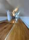 Additional living space featuring baseboards, a baseboard heating unit, vaulted ceiling, and wood finished floors