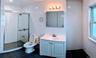 Bathroom with toilet, tile patterned floors, vanity, and a stall shower